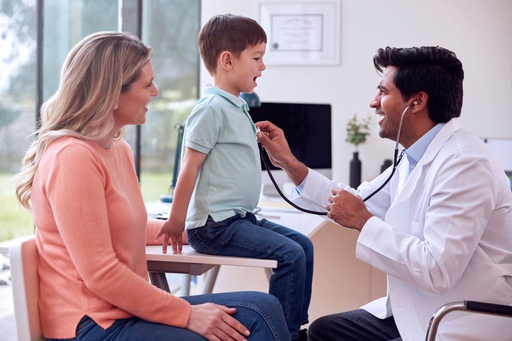 Doctor checking heartbeat of a kid.