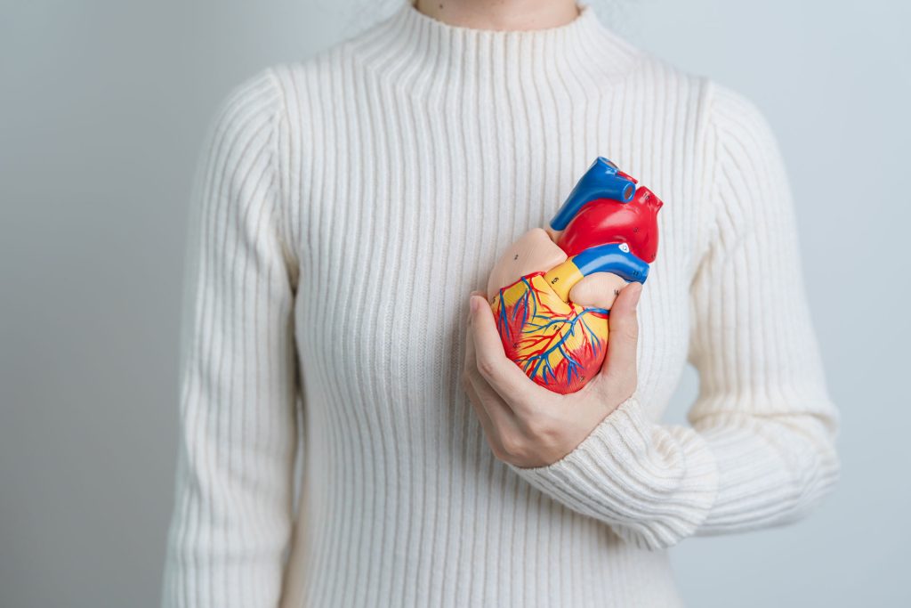 Woman holding a heart model for heart failure awareness.