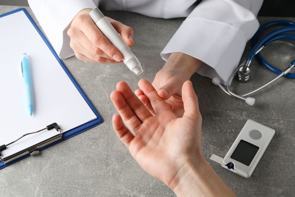 Doctor checking blood sugar level of a patient.