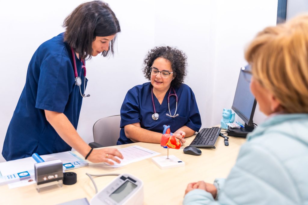 Woman getting health screening by two doctors.