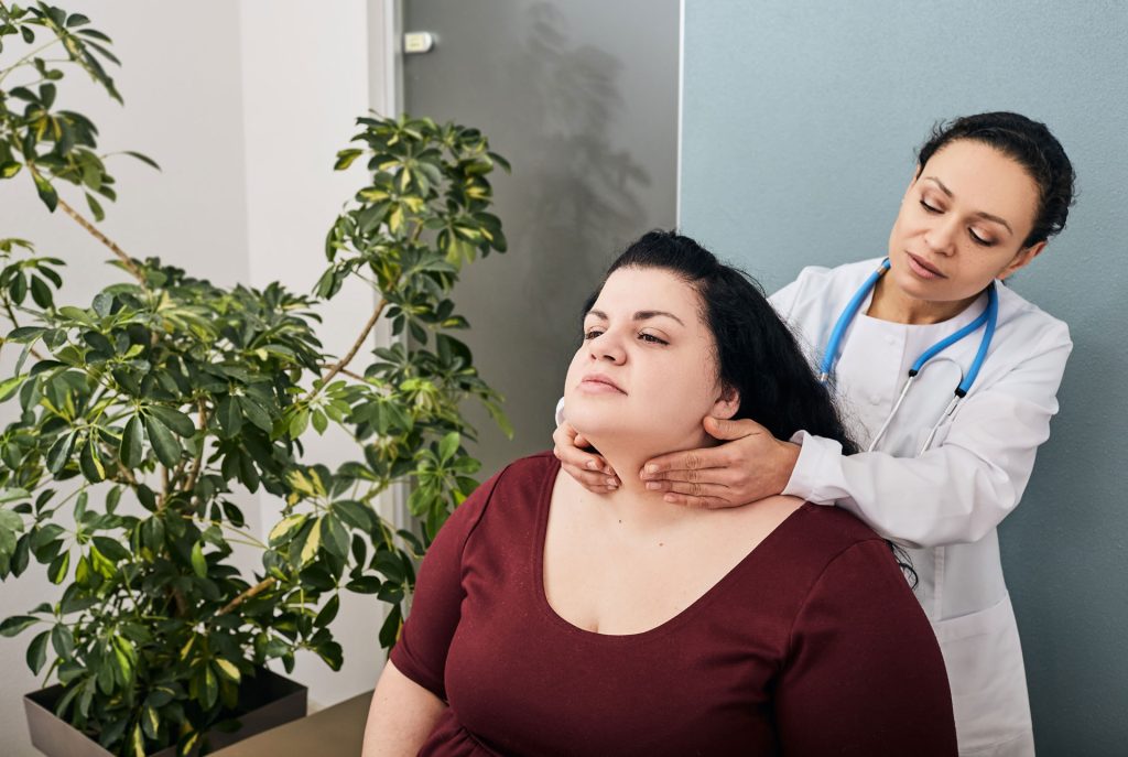 Endocrinologist examine a woman patient thyroid disorder.
