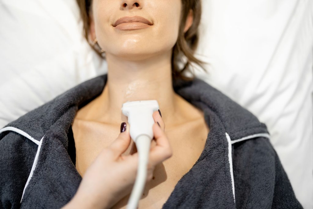 Doctor examining a woman with thyroid disorder.