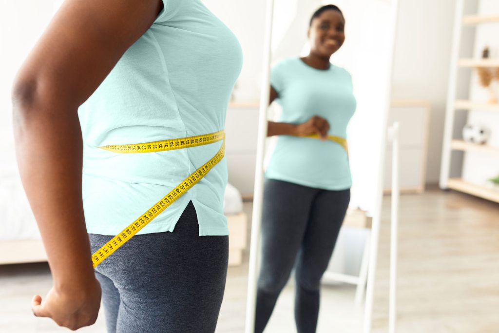 Woman measuring her waist.