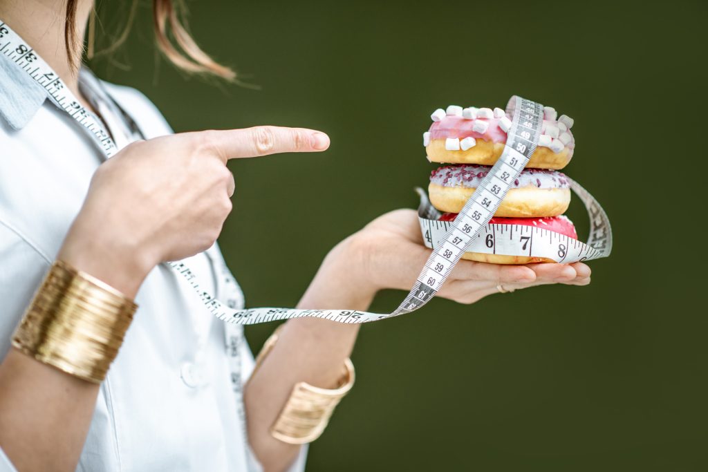Nutritionist holding donuts.