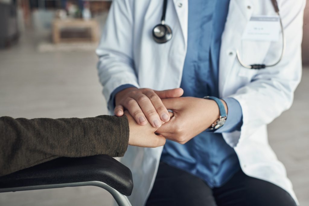 Doctor holding patient hand.