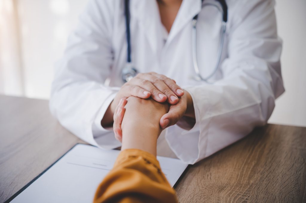 Doctor holding patient hand.