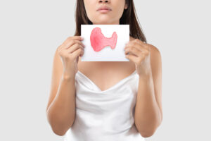 Woman holding a thyroid drawing.